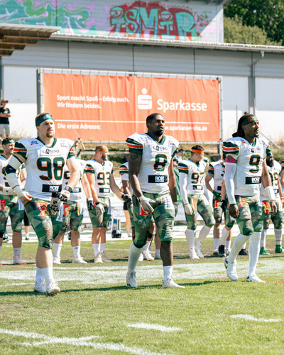 Team Captains Kamphausen, Revels und Settles auf dem Weg zum Coin Toss
