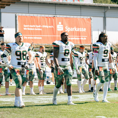 Team Captains Kamphausen, Revels und Settles auf dem Weg zum Coin Toss